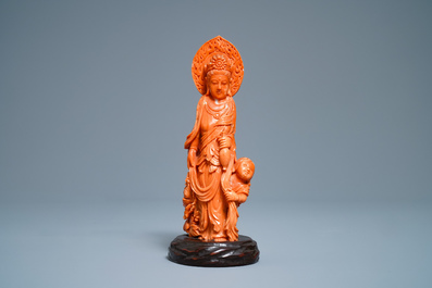 A Chinese carved red coral group of Guanyin with child, 19th C.