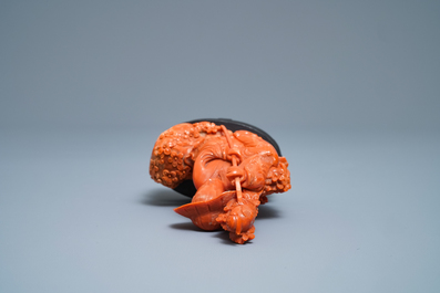 A Chinese carved red coral group of a boy with a parrot, 19/20th C.