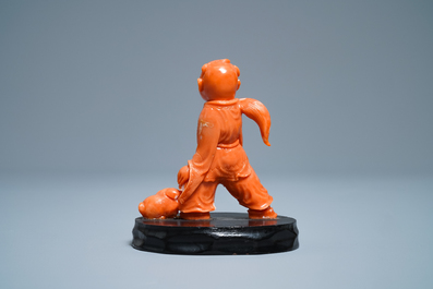 A Chinese carved red coral group of a boy with a dog, 20th C.