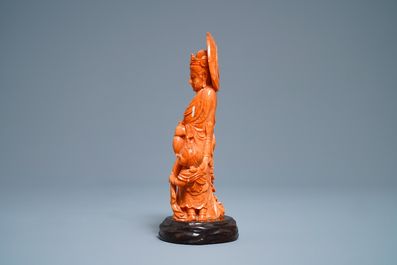 A Chinese carved red coral group of Guanyin with child, 19th C.