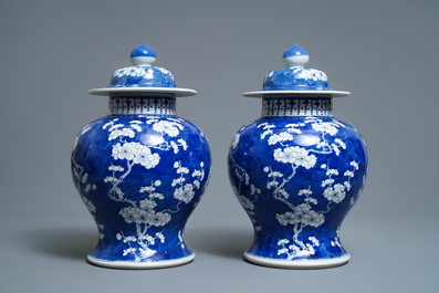 A pair of Chinese blue and white 'prunus on cracked ice' vases and covers, 19th C.