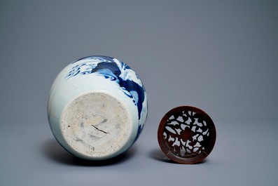 A Chinese blue and white ginger jar with figures in a landscape and a wooden cover, Transitional period