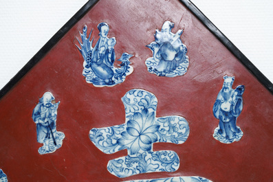 Een Chinese rood gelakte plaquette ingezet met blauw-wit porselein, 19/20e eeuw