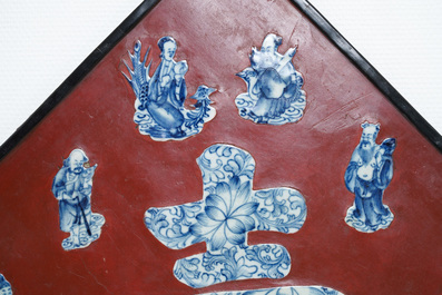 Une plaque laqu&eacute;e rouge incrust&eacute;e de porcelaine de Chine en bleu et blanc, 19/20&egrave;me