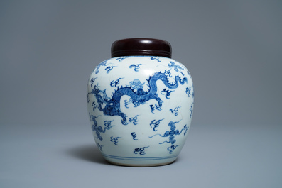 A Chinese blue and white 'dragon and phoenix' jar with wooden cover and stand, Kangxi