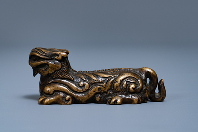 Een Chinees bronzen scrollgewicht in de vorm van een mythisch dier, Ming