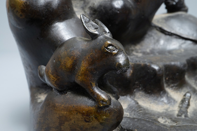 A large Chinese bronze group with Guanyin with child on a rock, Ming