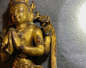 Een Sino-Tibetaanse verguld bronzen en ingelegde figuur van Boeddha, Ming