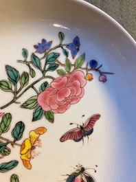 A Chinese famille rose 'ruby back' saucer dish with butterflies among flowers, Yongzheng