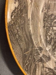 Un plat en porcelaine de Chine grisaille &agrave; d&eacute;cor du 'Retour de la chasse' avec une armoirie au dos, Qianlong