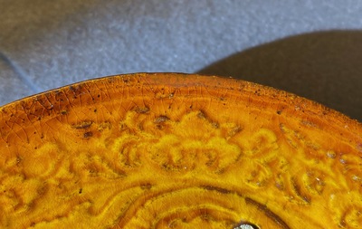 Een Chinees amber geglazuurd bord met reli&euml;fdecor, Liao (916-1125)