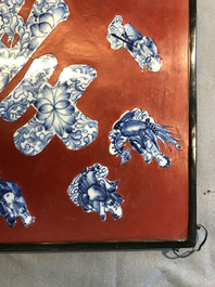 Une plaque laqu&eacute;e rouge incrust&eacute;e de porcelaine de Chine en bleu et blanc, 19/20&egrave;me