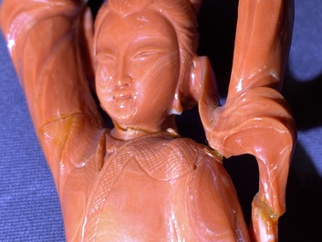 A Chinese carved red coral group of a lady and child, 19th C.