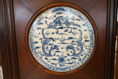 Un paravent en bois orn&eacute; de plaques en porcelaine de Chine en bleu et blanc, 19&egrave;me