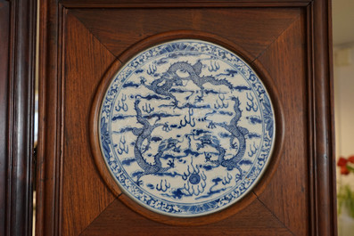 Un paravent en bois orn&eacute; de plaques en porcelaine de Chine en bleu et blanc, 19&egrave;me