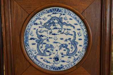 Un paravent en bois orn&eacute; de plaques en porcelaine de Chine en bleu et blanc, 19&egrave;me