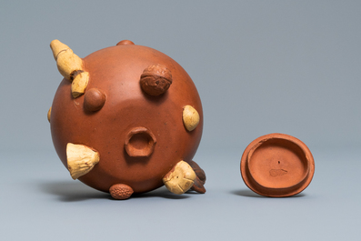 A Chinese Yixing stoneware relief-decorated teapot with nuts and fruits, impressed mark, 19th C.