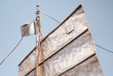 A large Chinese silver model of a junk on carved wooden stand, 19th C.
