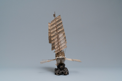 A large Chinese silver model of a junk on carved wooden stand, 19th C.