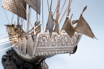 A large Chinese silver model of a junk on carved wooden stand, 19th C.