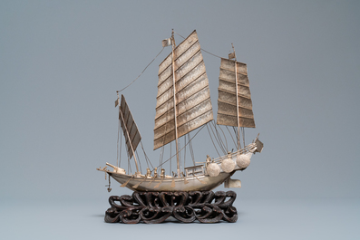 A large Chinese silver model of a junk on carved wooden stand, 19th C.