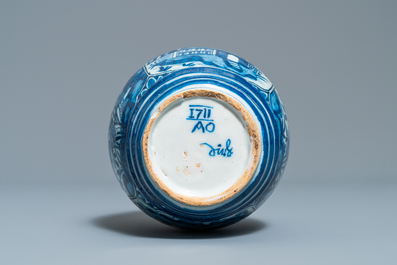 Een blauw-witte Delftse tonvormige jeneverfles met chinoiserie decor, gedateerd 1711