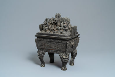 A large Chinese bronze censer and cover with animals near a hilly landscape, Ming