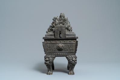 A large Chinese bronze censer and cover with animals near a hilly landscape, Ming