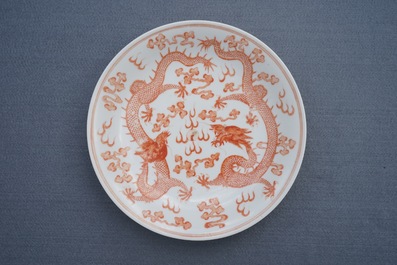 Une assiette aux dragons en porcelaine de Chine rouge de fer au dos rouge de rubis, marque et &eacute;poque de Guangxu