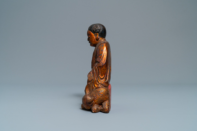 A Chinese gilt and laquered wooden group with a boy on an ox, 18/19th C.