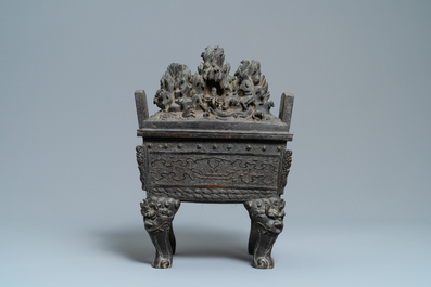 A large Chinese bronze censer and cover with animals near a hilly landscape, Ming