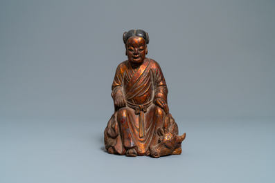 A Chinese gilt and laquered wooden group with a boy on an ox, 18/19th C.