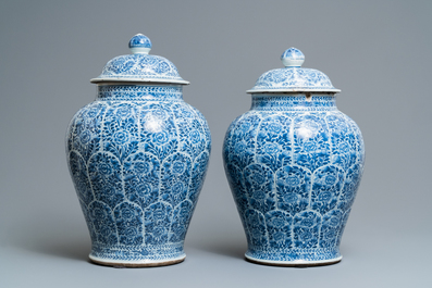A pair of Chinese blue and white vases and covers with floral design, Kangxi