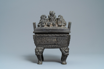 A large Chinese bronze censer and cover with animals near a hilly landscape, Ming