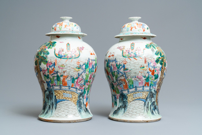 A pair of Chinese famille rose 'spring festival' vases and covers, 19th C.