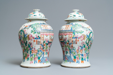 A pair of Chinese famille rose 'spring festival' vases and covers, 19th C.