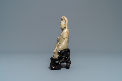 Een Chinees zeepstenen figuur van Guanyin op houten sokkel, 19e eeuw