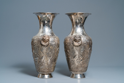 A pair of exceptional large Chinese relief-decorated silver vases, 19th C.