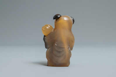 A Chinese carved agate snuff bottle in the shape of a boy, 19/20th C.