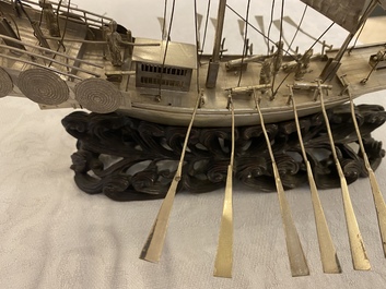 A large Chinese silver model of a junk on carved wooden stand, 19th C.