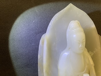 Een Chinese celadon jade figuur van Guanyin op lotustroon, 19/20e eeuw