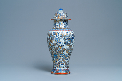 A Chinese blue and white clobbered vase and cover with floral design, Kangxi