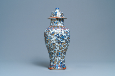 A Chinese blue and white clobbered vase and cover with floral design, Kangxi