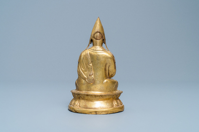 A Sino-Tibetan gilt bronze figure of a Lama, Ming