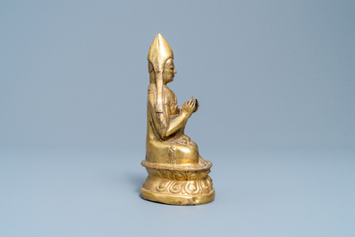 A Sino-Tibetan gilt bronze figure of a Lama, Ming