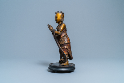 Een Chinese gelakte en vergulde bronzen figuur van een dienaar, Ming