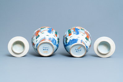 A pair of Chinese wucai vases and covers, Kangxi mark, 19th C.