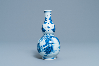 A Chinese blue and white double gourd vase with figures in a landscape, Transitional period