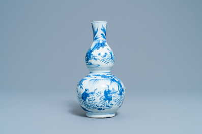 A Chinese blue and white double gourd vase with figures in a landscape, Transitional period