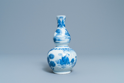 A Chinese blue and white double gourd vase with figures in a landscape, Transitional period